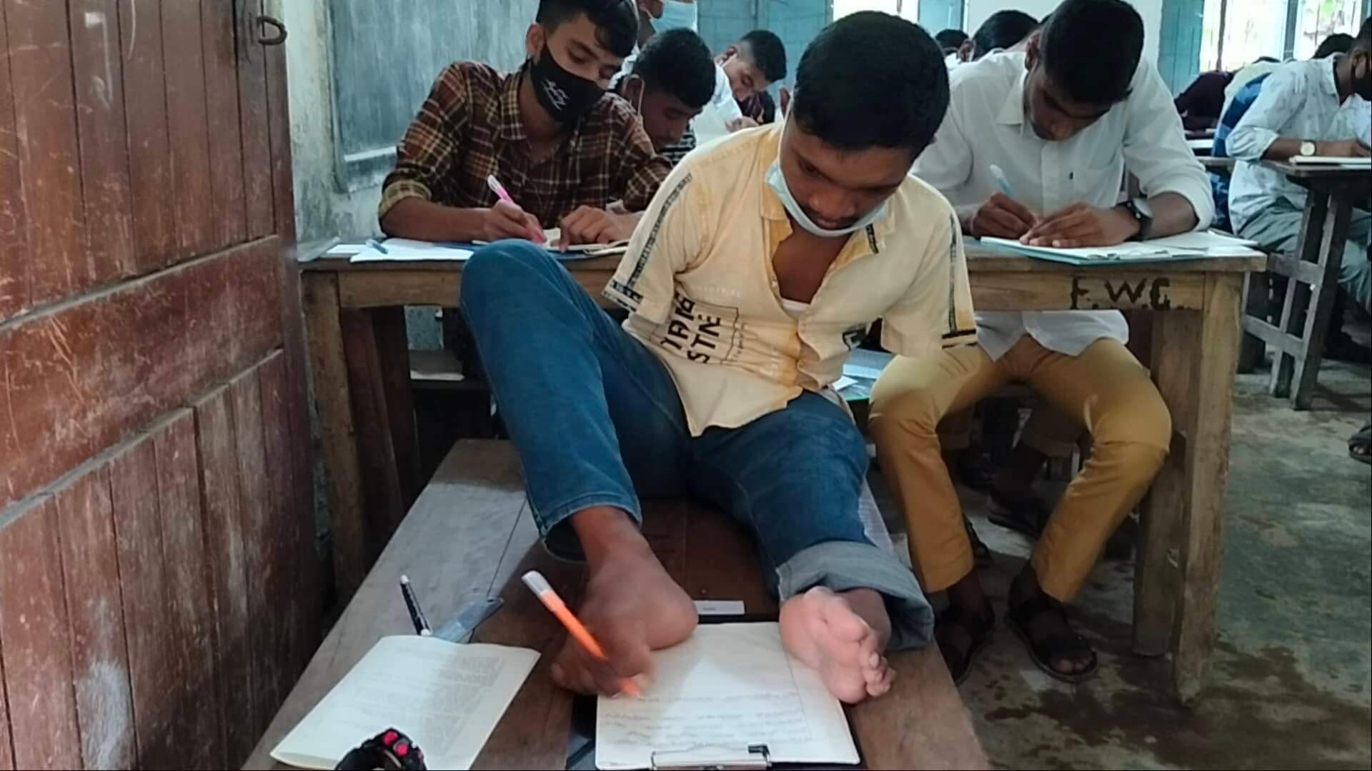 দুই হাত নেই, পা দিয়ে লিখেই এসএসসি পরীক্ষা দিচ্ছে ফুলবাড়ীর মানিক